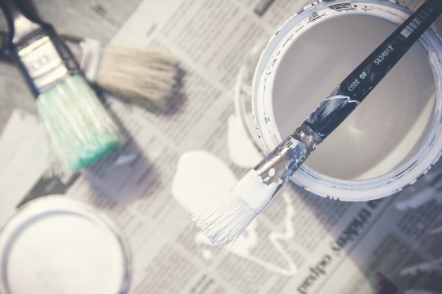 An image of a open paint pot on newspaper.
