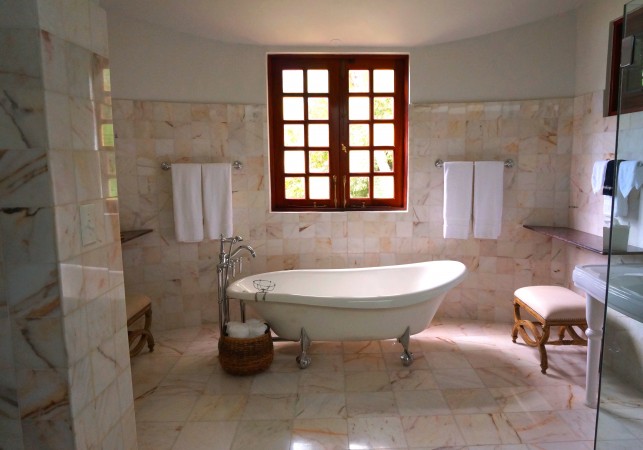 An image of a traditional, Victorian style bathroom with a freestanding roll top bath.